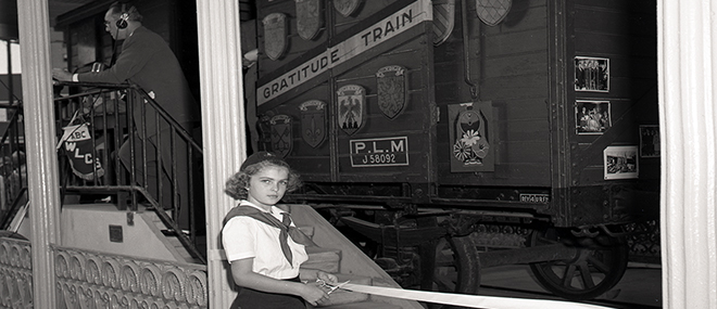 A girl poses by the Merci Train, a gift to Louisiana from France after World War II, at Louisiana's Old State Capitol. John Gasquet, photographer